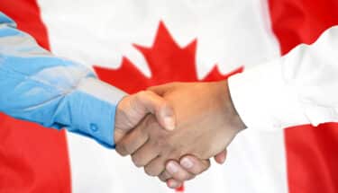 handshake on Canada flag background.